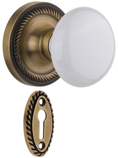Rope Rosette Mortise Lock Set With White Porcelain Door Knobs in Antique Brass.